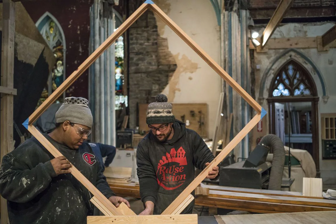 Christopher Tyes, left, and lead instructor Danny Solomon cut notches in a frame at Assembly House, the former Immaculate Conception Catholic Church, where the Society for the Advancement of Construction-Related Arts trains new craftspeople